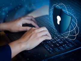 A person using a computer with a symbol representing ddos protection.