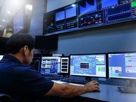 Man working with multiple computer displays.