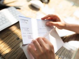 Businessperson Opening Envelope With Paycheck