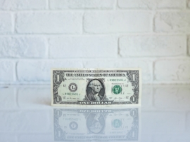 A dollar on a table representing payroll.