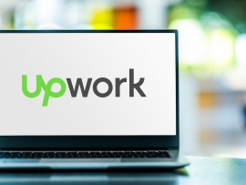 Laptop computer displaying logo of Upwork.